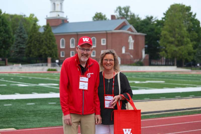 a man and woman standing on a football field