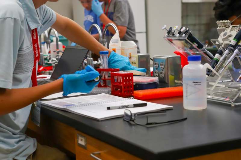 a person in gloves working in a laboratory