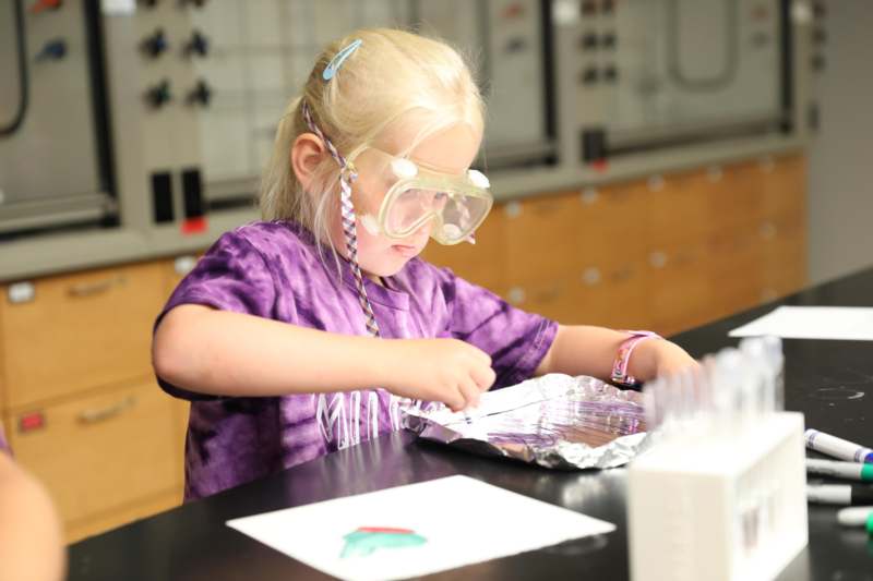 a girl wearing goggles and holding a foil