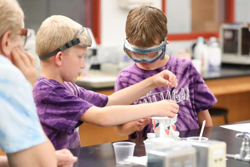 a group of kids wearing goggles and standing next to each other