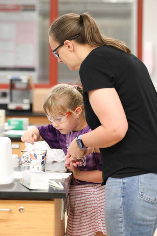 a woman and a child making a science experiment
