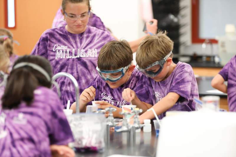 a group of kids wearing purple shirts