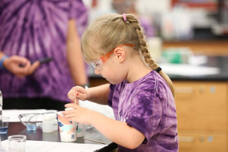 a girl in a purple shirt painting