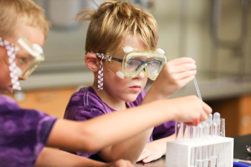 a group of kids wearing safety goggles and holding tubes
