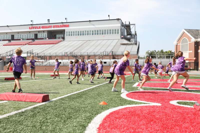 a group of children running on a football field