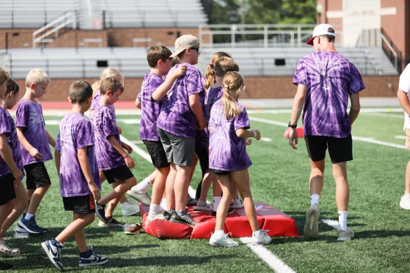 a group of kids standing on a red object on a field