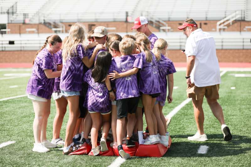 a group of kids standing on a football field