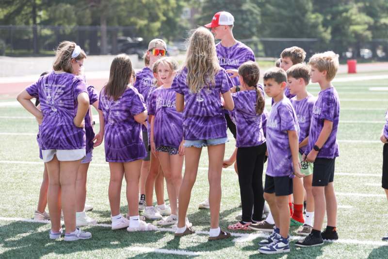 a group of kids in purple shirts