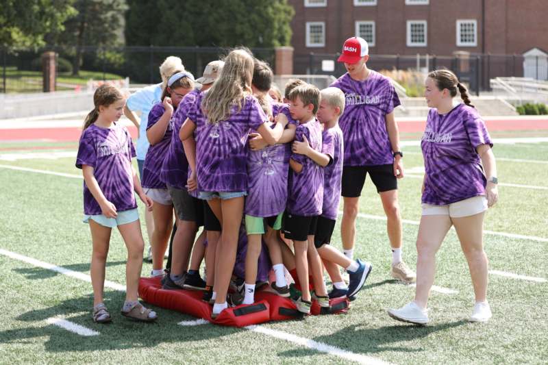 a group of kids standing on a pile of people on a field