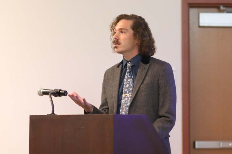 a man standing at a podium with a microphone