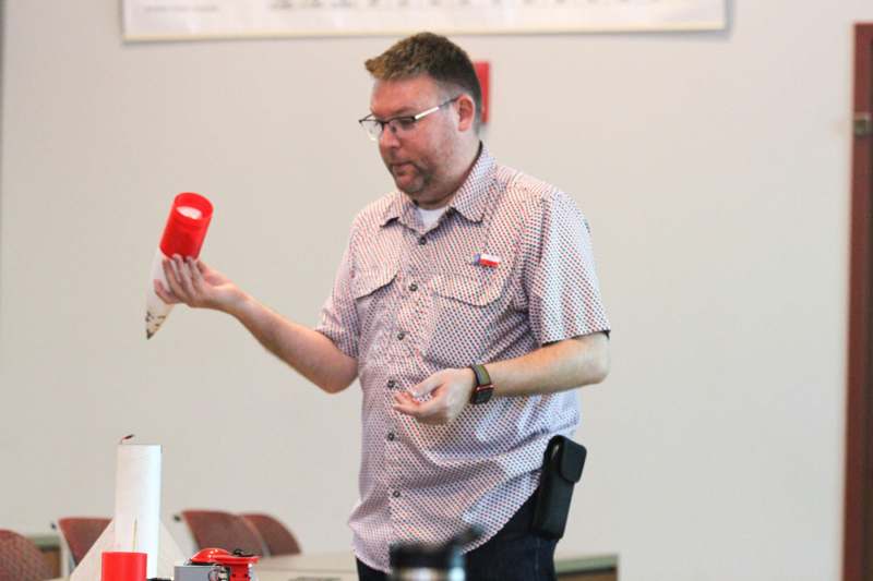 A man holding pieces of a model rocket