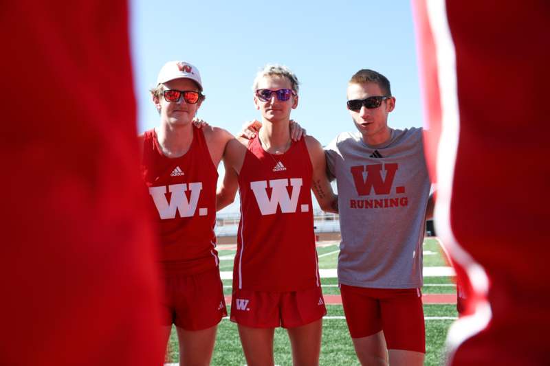 a group of men in red shirts and sunglasses on a field