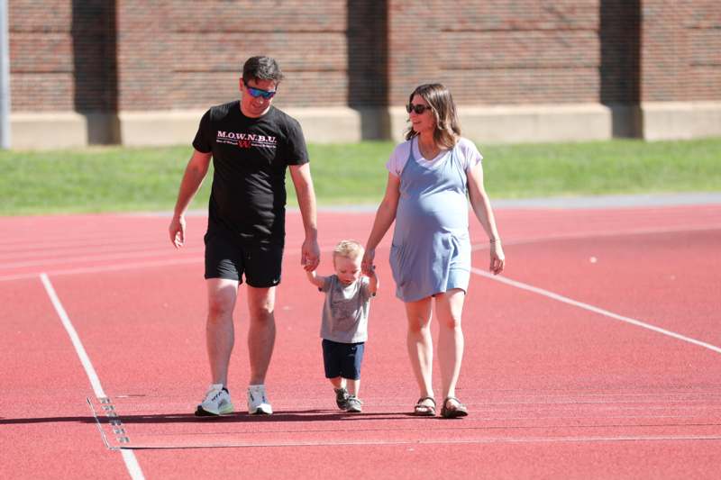 a man and woman walking with a child