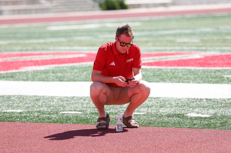 a man squatting on a sports field
