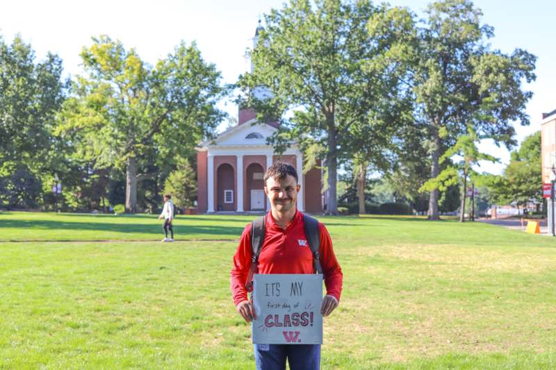 a man holding a sign in front of a building
