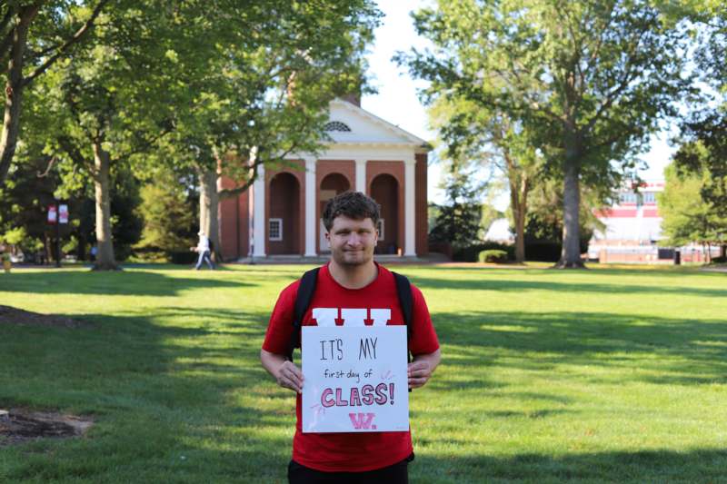 a man holding a sign in front of a building
