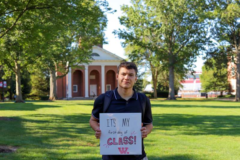 a man holding a sign in front of a building
