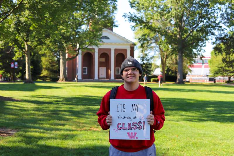a man holding a sign in front of a building