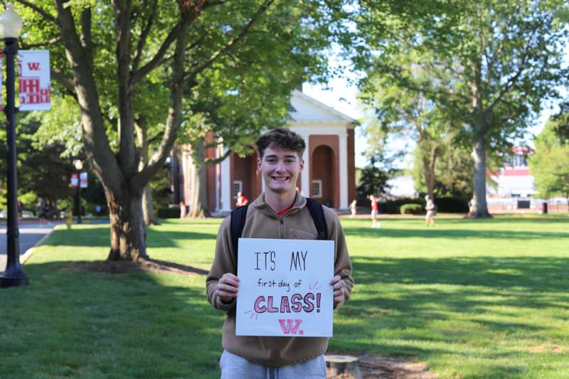 a man holding a sign in front of a building