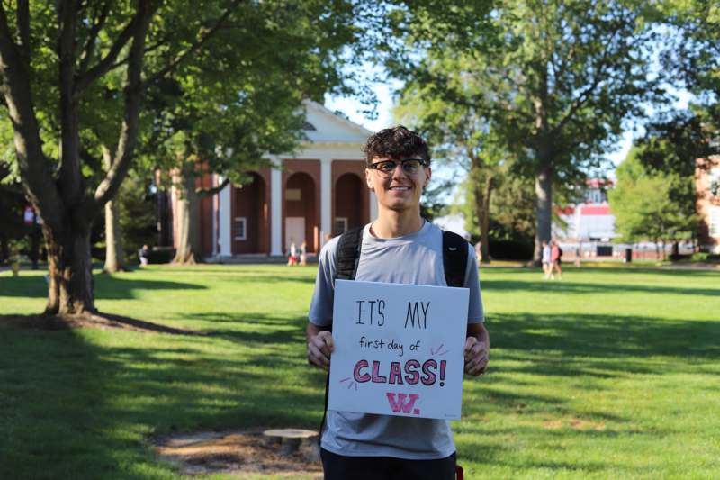 a man holding a sign in front of a building