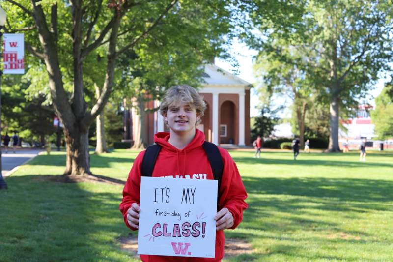 a boy holding a sign in front of a building