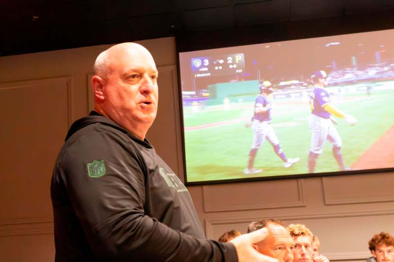 a man standing in front of a large screen