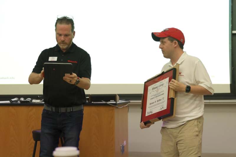 a man holding a tablet and a man holding a frame