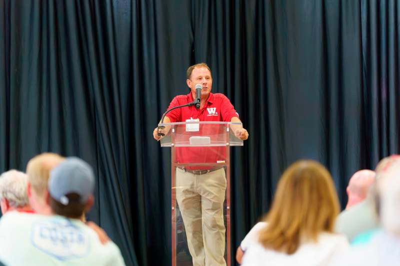 a man standing at a podium speaking into a microphone