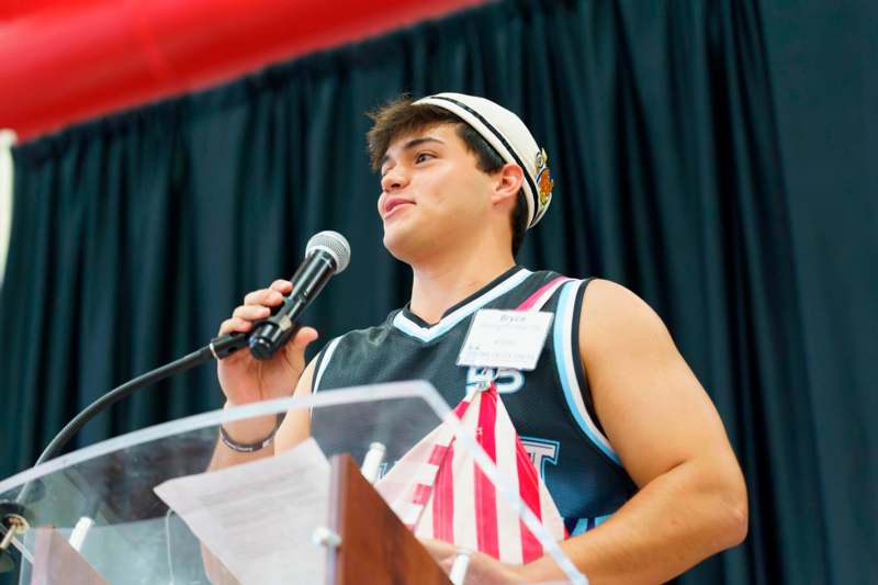 a man standing at a podium speaking into a microphone