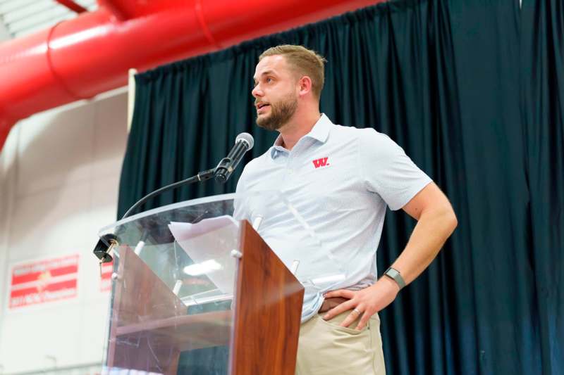 a man standing at a podium with a microphone