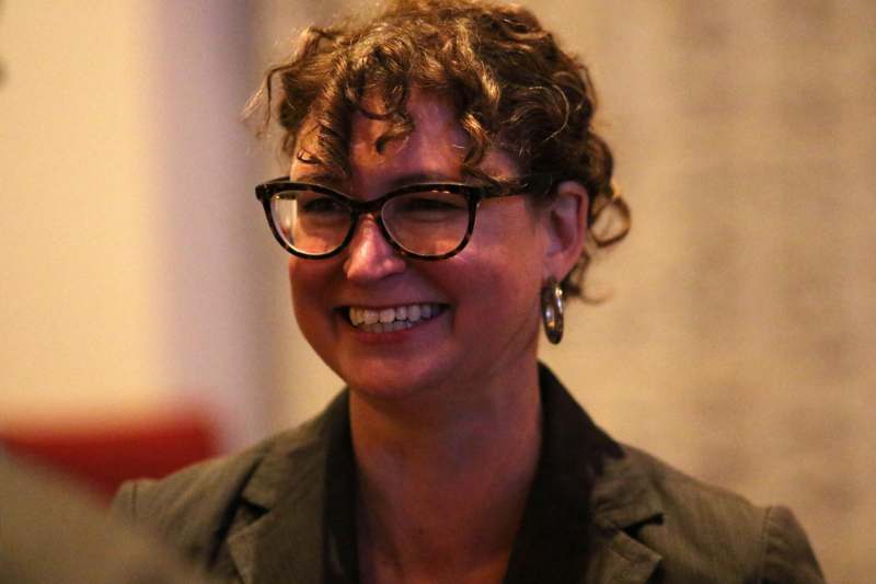 a woman wearing glasses and smiling