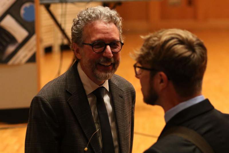 a man in a suit and tie talking to another man