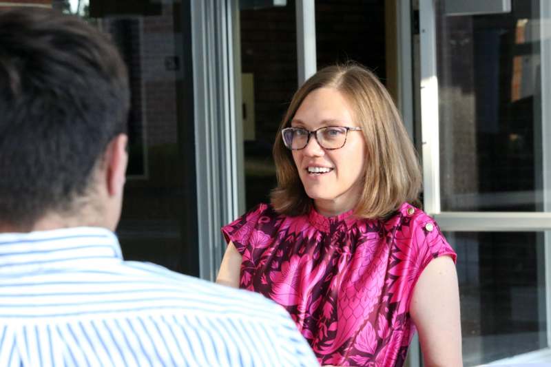 a woman in a pink shirt talking to a man