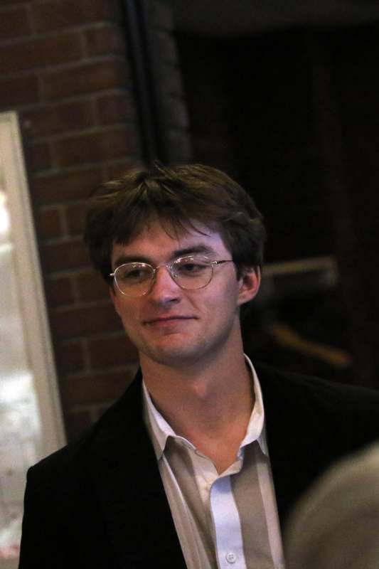 a man wearing glasses and a black jacket