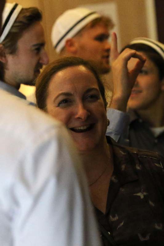 a woman smiling with other people behind her