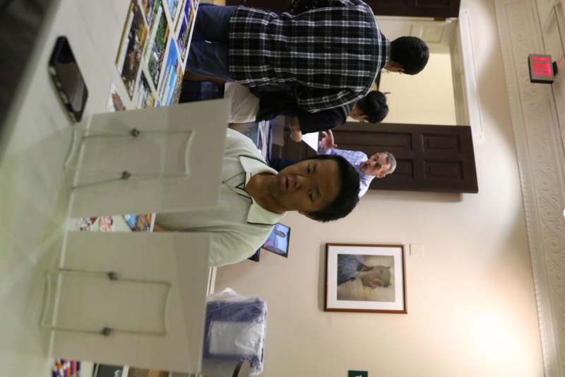 a man sitting at a table with pictures on it