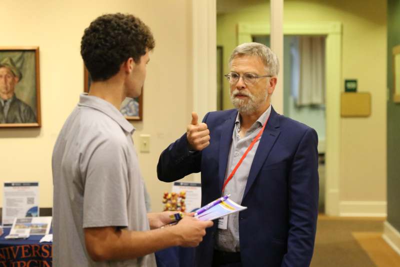 a man in a suit talking to a man in a room