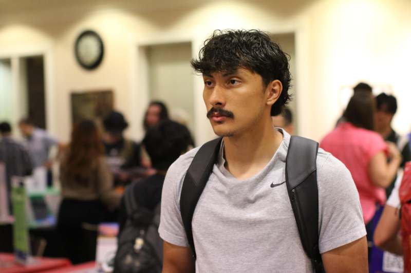 a man with a mustache and backpack