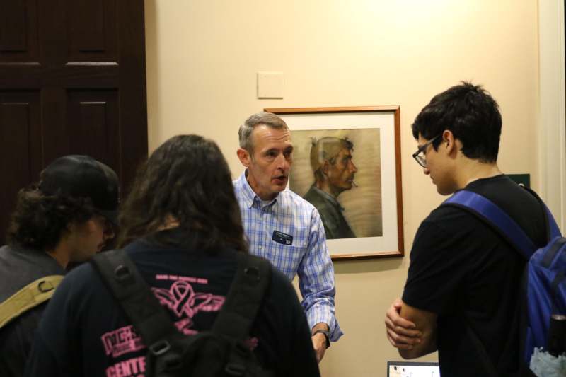 a group of people standing around a man talking