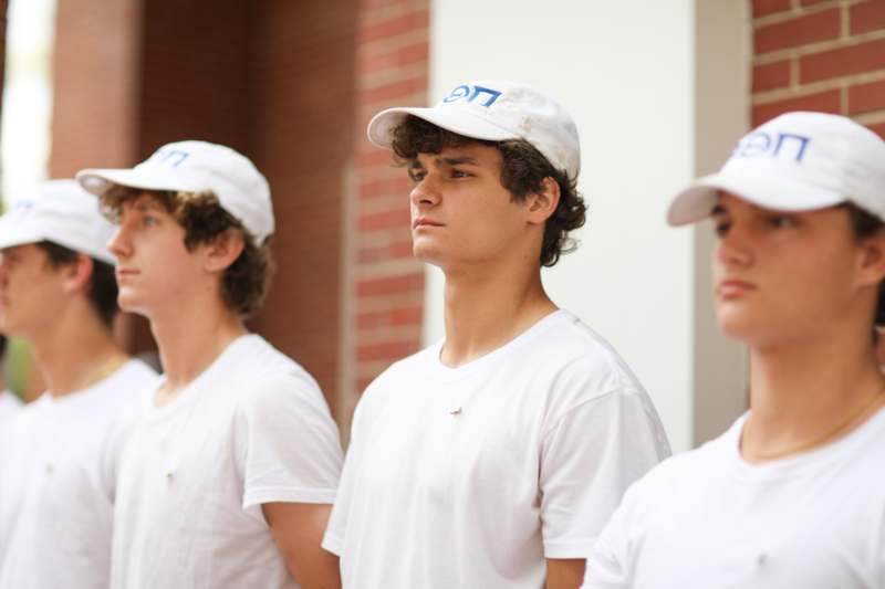 a group of men wearing white shirts and hats