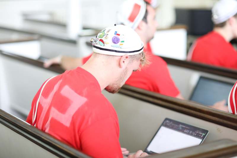 a man in a red shirt with a laptop