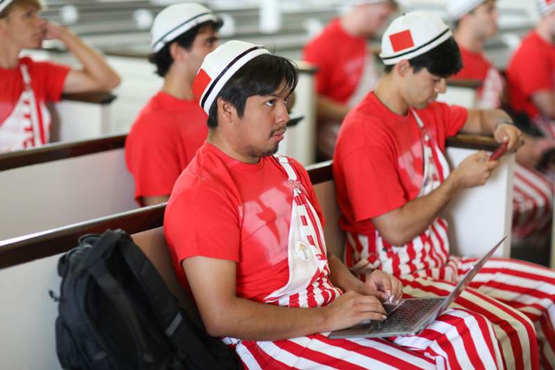 a group of men in matching outfits sitting in a church
