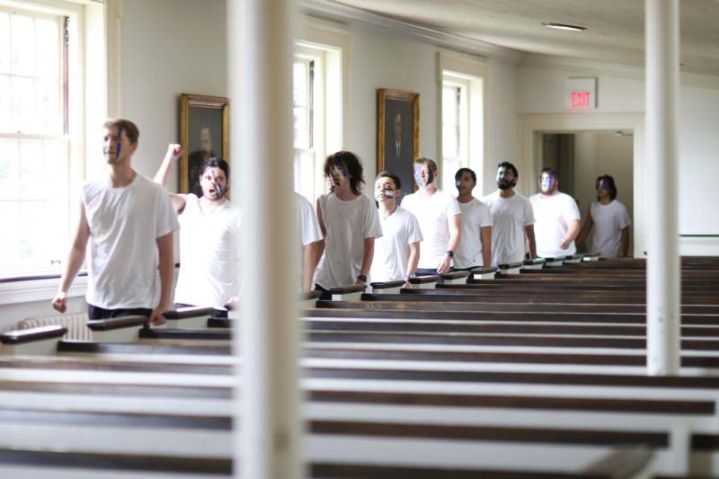 a group of people in white shirts with blue paint on their faces