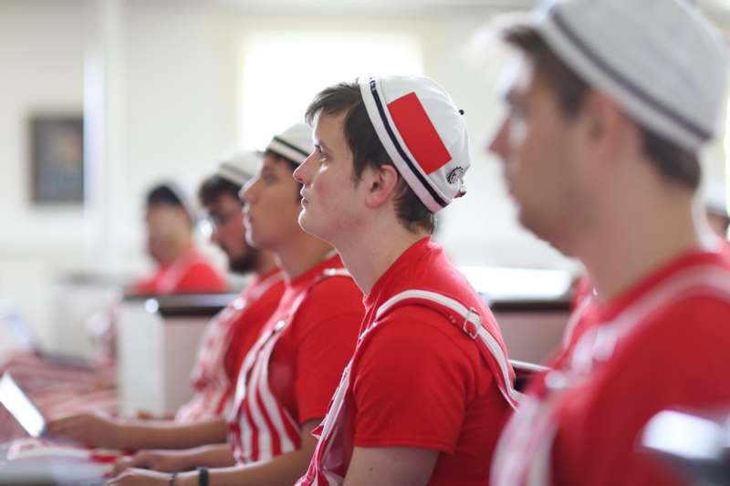 a group of men in red shirts and white hats