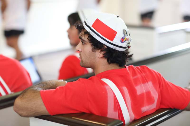 a man in a red shirt and white hat