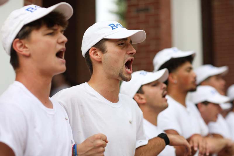 a group of men wearing white shirts and hats