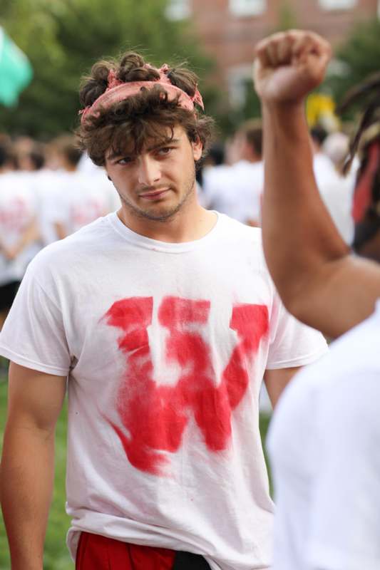 a man wearing a white shirt with red paint on his shirt