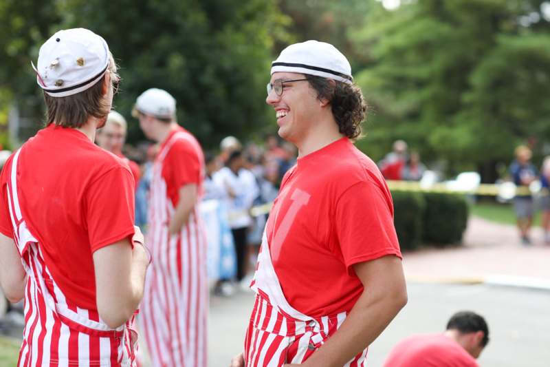 a group of men wearing red and white striped shirts and hats