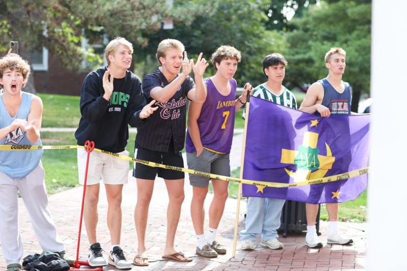 a group of men standing on a brick path holding a flag