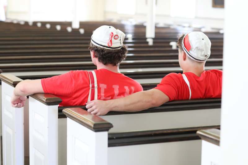 two men sitting in a church pew